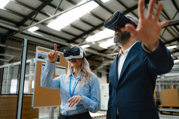 Engineers talking project using VR, in modern industrial factory. Virtual reality in manufacturing industry, Smart glasses guiding female and male manager through process and planing.