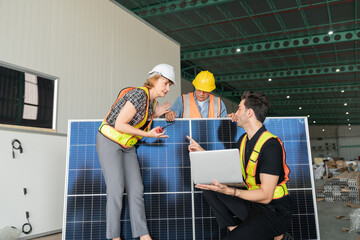 .Engineer and technician discussing over solar power plant with holding laptops and walkie talkie..