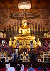 BANGKOK, THAILAND - November 28, 2023: Golden Buddha statue in meditation posture located inside the temple for those who have faith to come to pay respect and worship in temples in Thailand.