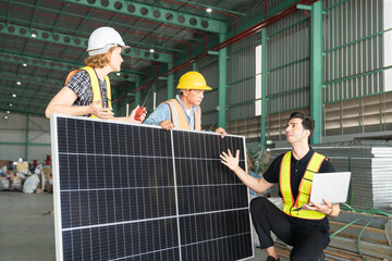 Team of engineers and workers using solar panels in a large warehouse.This is a freight...