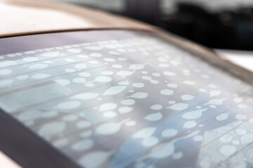 Close-up car windshield film or light filter film on the glass peels off, resulting in air bubbles...