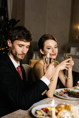 Merry Christmas! Happy family are having dinner at home. Celebration holiday and togetherness near tree.Father, mother and son at the Christmas table. Christmas and New Year concept