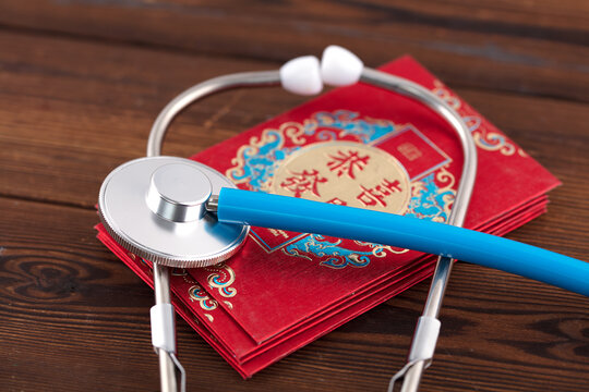 Stethoscope and red envelope together.The Chinese characters in the picture mean: "Congratulations on getting rich"