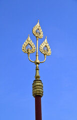 Closeup of Beautiful Golden Royal Line Thai Lantern located inside a Thai Buddhist temple with blue sky background at Thailand.