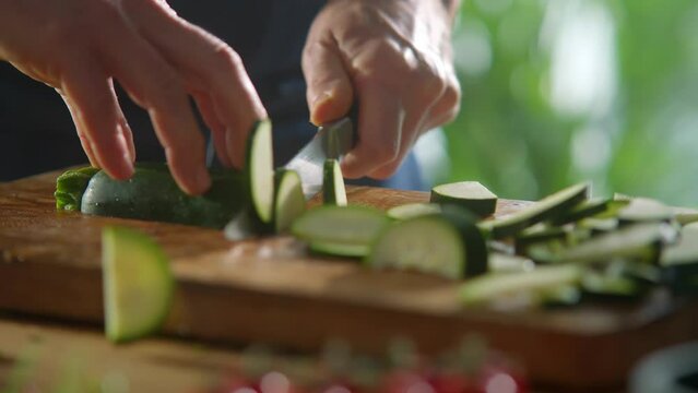 Slicing Cucumber with Sharp Knife on Wooden Cutting Board