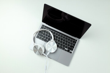 Big headphones, on a table with a laptop.
