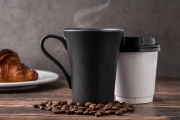 Relaxing americano coffee in black porcelain cup and take away cup on wooden table