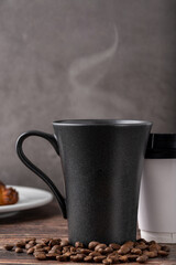 Relaxing americano coffee in black porcelain cup and take away cup on wooden table