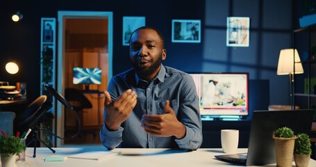 Happy influencer in home studio using professional camera and mic to film live broadcast for online streaming platforms. Viral online star hosts q a session with followers