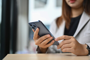 Select focus on businesswoman texting messages, communicating in social network on mobile phone