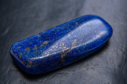 Niebieski kamień szlachetny lapis lazuli leży na czarnym tle