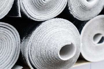 Thermal insulation material made of foamed polyethylene with a foil insert. Building materials in rolls in a showcase or warehouse of a specialized store. Close-up. selective focus