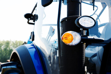 Tractor headlights and turn signal. A fragment of agricultural machinery in close-up.