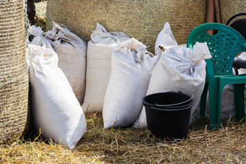 Feed in large bags for farm animals on the background of a haystack. Harvesting food for cattle....