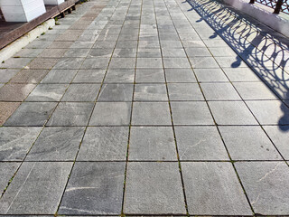 paving stone tiles of square and rectangular shape of gray in perspective. Close up road surface....