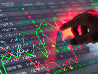Trader checking stock market graph data on screen