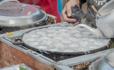 Thai Pancake, Male hands making khanom krok Traditional Thai desserts with delicious - obrazy, fototapety, plakaty