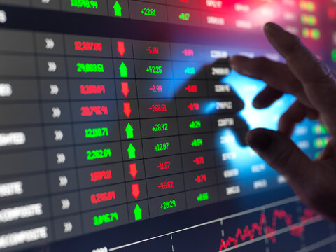 Hand of trader checking stock market data on screen
