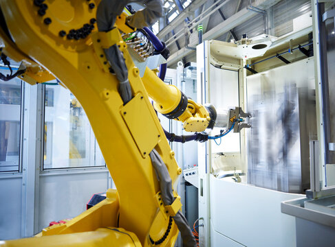 Yellow robotic arm in factory