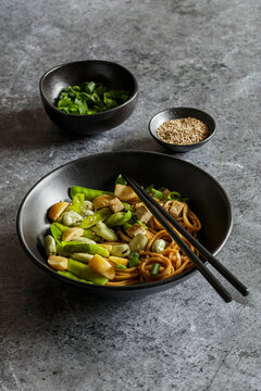 Bowl of vegan miso udon bowl with tofu, snap peas, broad beans and turnips
