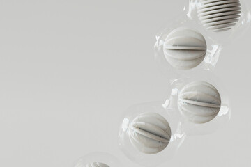 3D render of row of plastic wrapped spheres floating against white background