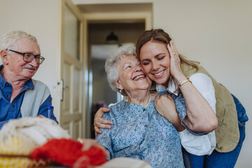 Happy senior woman embracing healthcare worker at home