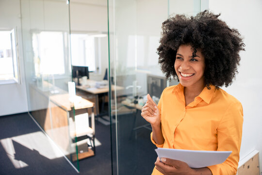 Excited businesswoman holding document at office