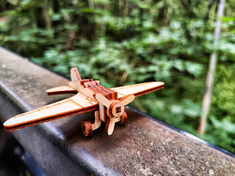 Vintage toy wooden airplane in nature. Private adventure traveling by flight. Aircraft for nature protection, eco friendly, fire extinguishing, rescue of victims. Plane crash, breakdown