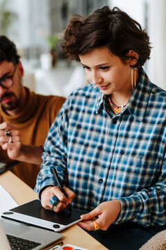 Young design illustrator working on graphic tablet at office