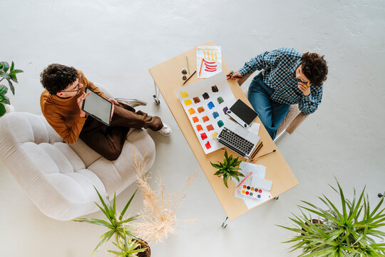 Graphic designers planning together sitting at desk in office