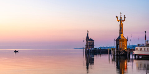 Germany, Baden-Wurttemberg, Konstanz, Harbor on shore of Bodensee at dawn with Imperia statue in foreground