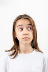 Little girl looks to the side in surprise on a white background isolated.