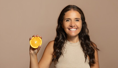 Happy caucasian senior woman with perfect skin care, show orange fruit