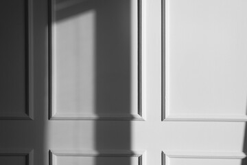 Light and shadow from window on beige wall indoors