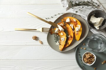 Delicious pumpkin slices served with thyme and cheese on white wooden table, flat lay