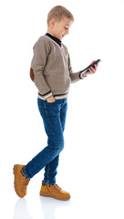 Full-length portrait of blonde seven year old boy walking a side and chatting on the cell phone...
