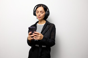 Portrait of a brunette woman with headphones and smartphone