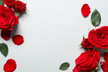 Beautiful red roses and petals on light background, flat lay. Space for text