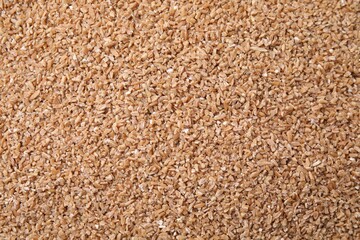 Dry wheat groats as background, top view