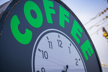 A partial view of a clock with coffee written, can be a graphic resource for creators or represent...