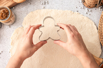 Form for Christmas cookies in female hands against the background of dough.