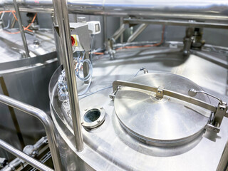  Stainless steel tanks with large round hatches, modern beverage production. Food industry.