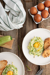 Breakfast of zucchini and eggs on a wooden background. Healthy breakfast with vegetables and eggs.
