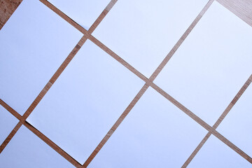 White blank A4 poster paper arrange diagonally on wooden background