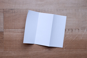 Blank white paper flyer for mock up on wooden background