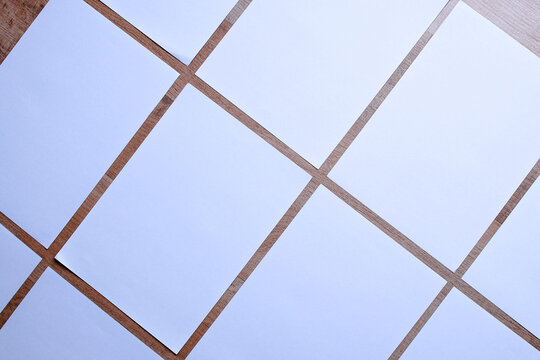 White blank A4 poster paper arrange diagonally on wooden background