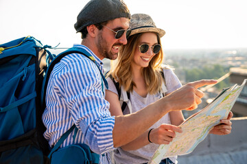 Happy couple on vacation sightseeing city with map. People travel fun honeymoon concept. - obrazy, fototapety, plakaty