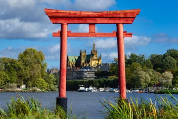Selbstklebende Fototapeten Japanese Torii gate in Metz at the plan d’eau with the Saint Stephen cathedral in the background © Reflexpixel