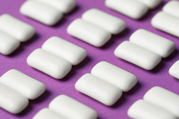 Tasty white bubble gums on purple background, closeup