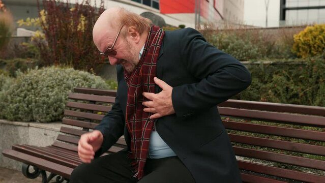 Elderly Health Concern An anxious senior bearded man feels unwell and upset, experiencing sudden chest pain, possibly signaling a heart attack in the city.